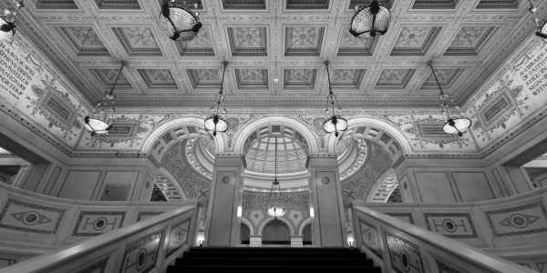 Ornate historic building interior with grand staircase and detailed ceiling.