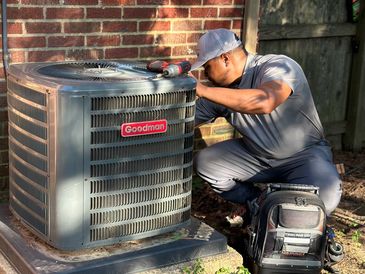 HVAC technician performing air conditioning repair and maintenance on a residential outdoor condenser in Memphis, TN.