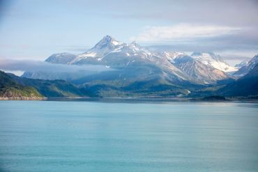 A landscape of snowy mountains seen from the water.