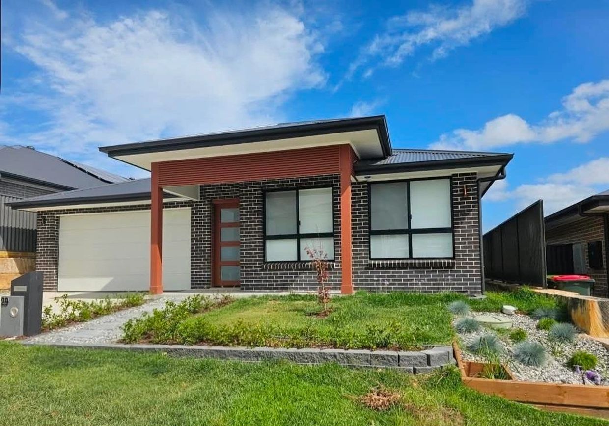 Modern single-story brick house with a well-maintained lawn and garden.
