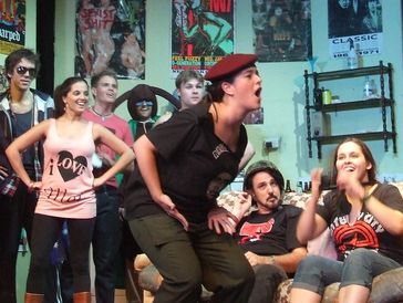 Group of people engaged in a lively theatrical or improv performance indoors.