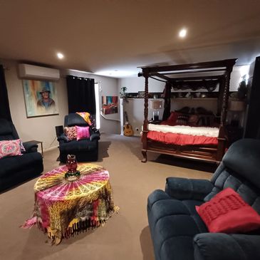 Cozy bedroom with a four-poster bed, armchairs, and a colorful table centerpiece.