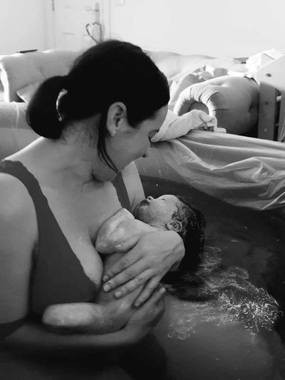 Picture of a mum meeting her baby after a home water birth in Stamford with doula support