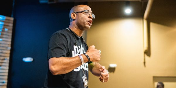 Man passionately speaking at an indoor event.