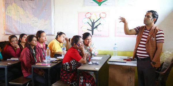 A teacher instructing a group of attentive students in a classroom.