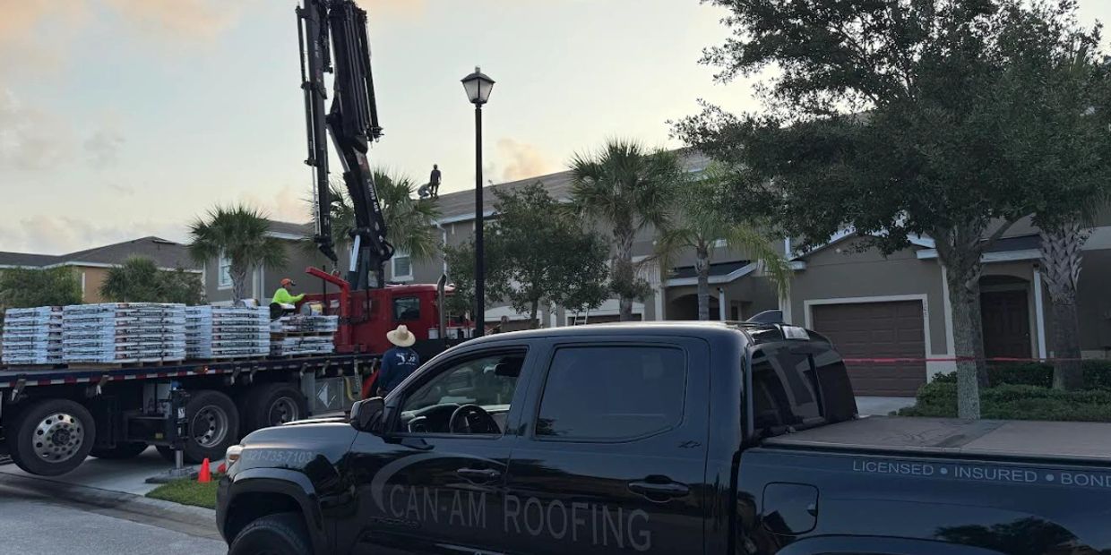 Roofing crew working on residential homes with trucks and equipment.