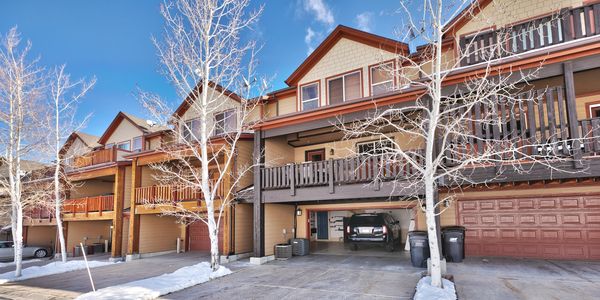 Row of modern townhouses with garages and bare trees in winter.