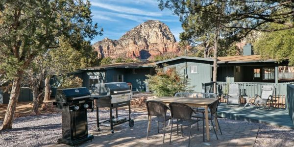 Outdoor patio with grills, dining area, and mountain view.