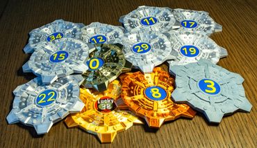 Colorful numbered game tokens arranged on a wooden surface.