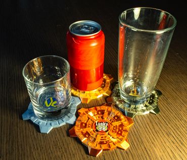 Three drink holders with a glass, a can, and an empty glass on a wooden table.