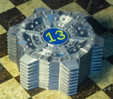 3D printed Vault 13 model from Fallout on a checkered surface.
