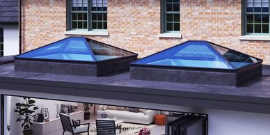 Two black aluminium lantern skylight windows on a flat roof extension