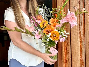 Woman holding a vibrant flower bouquet.