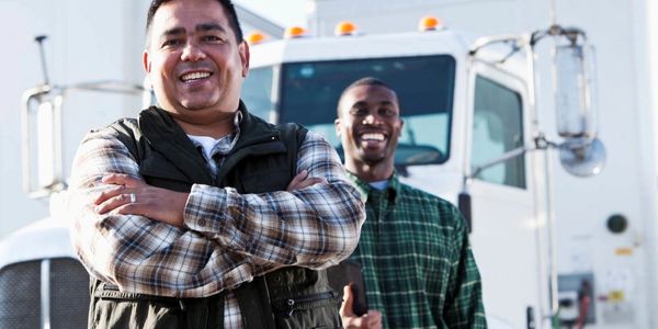Men standing in front of a truck.