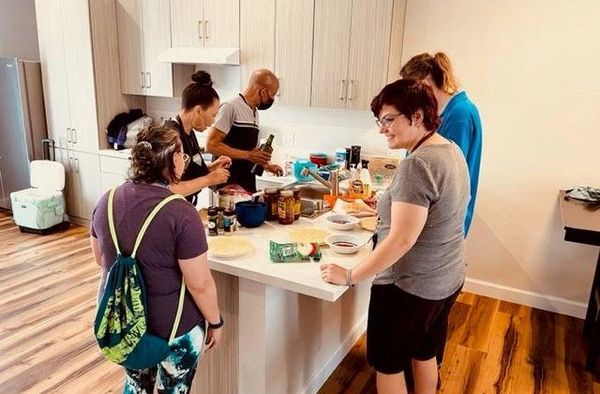 Group of people preparing food together in a kitchen.