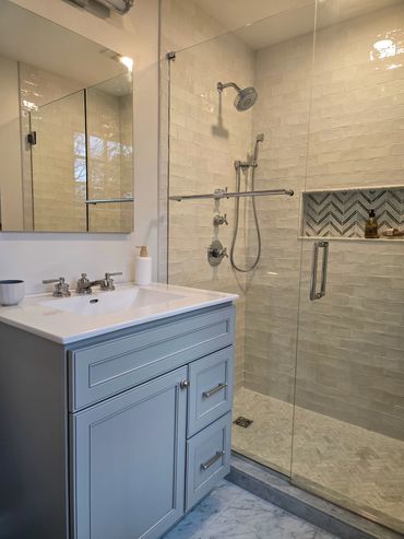 Modern bathroom with a glass shower and blue vanity.