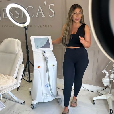 Woman demonstrating a beauty laser machine in a professional aesthetic clinic.