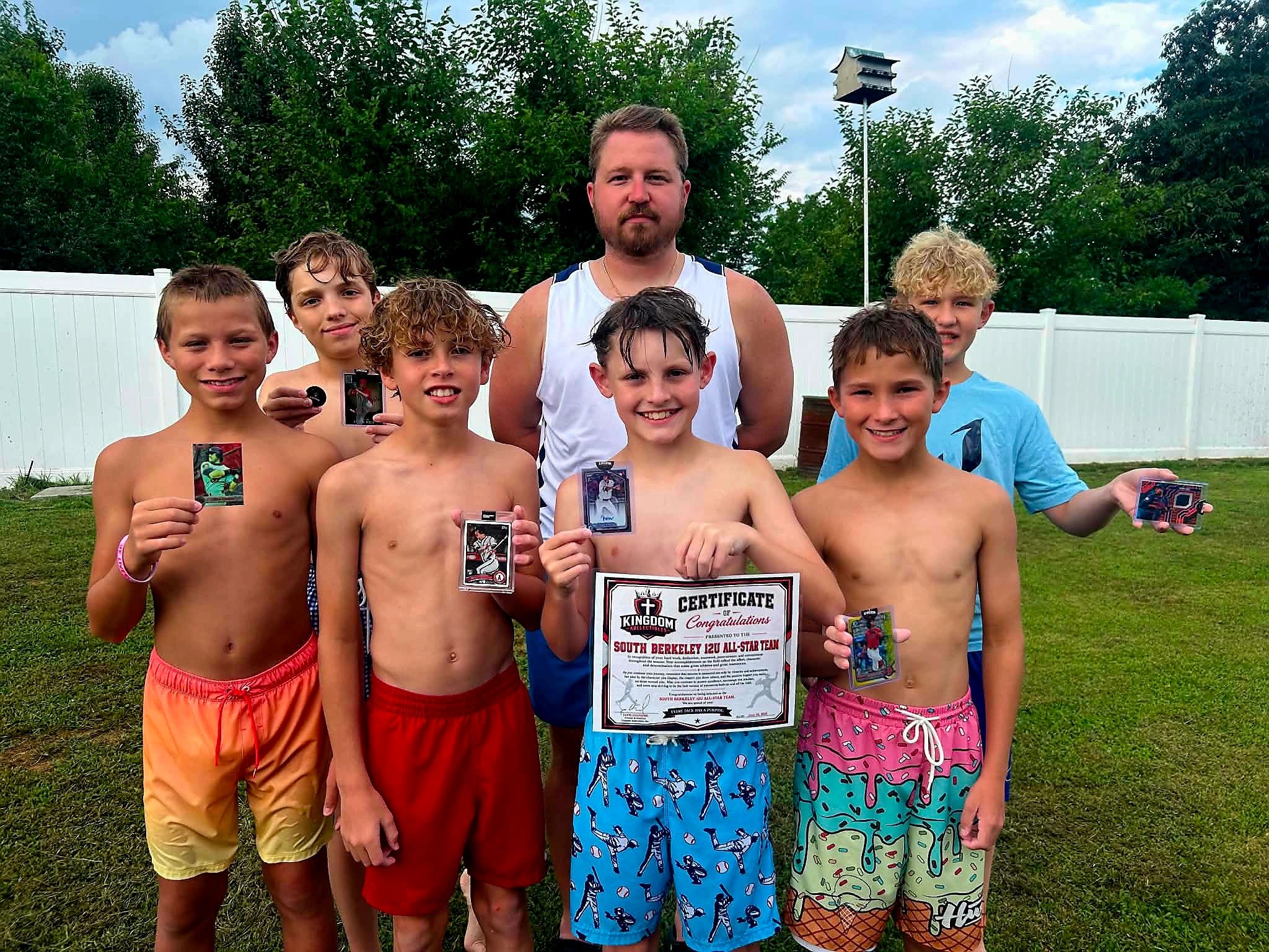 Group of boys showing baseball cards and a certificate.
