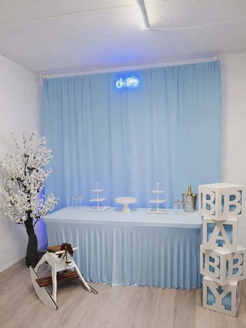 Blue-themed baby shower setup with decorations and a rocking horse.