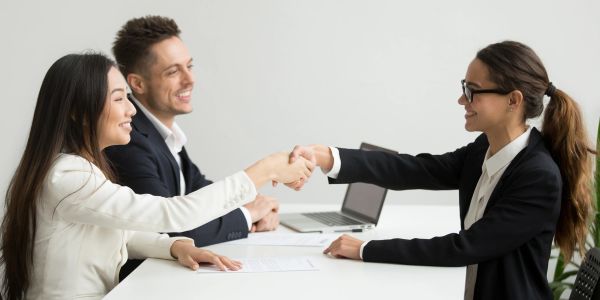 Two women shaking hands during a business meeting.