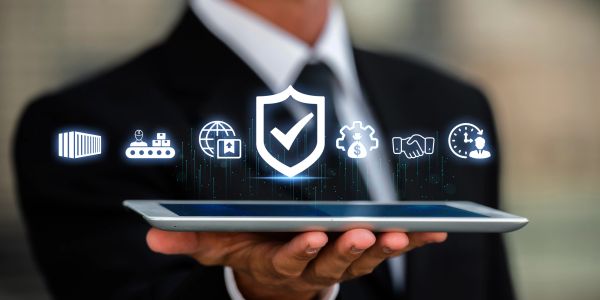 Businessman holding a tablet with digital security icons.