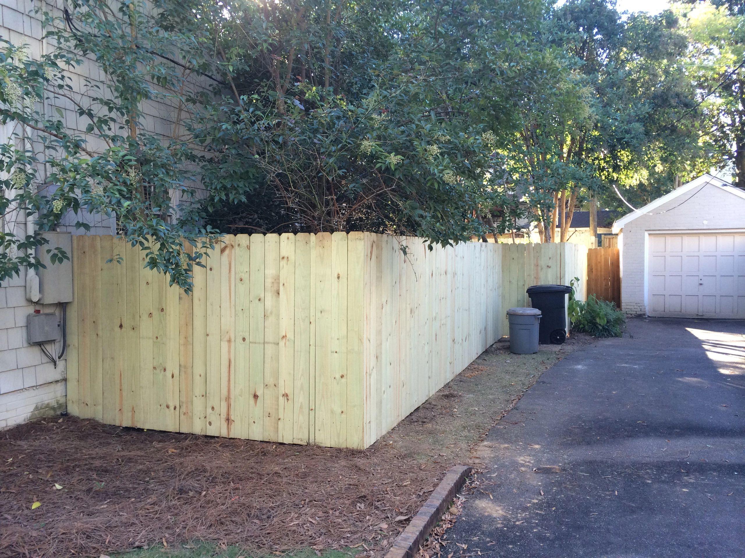 Beautiful wooden fence in leafy backyard.