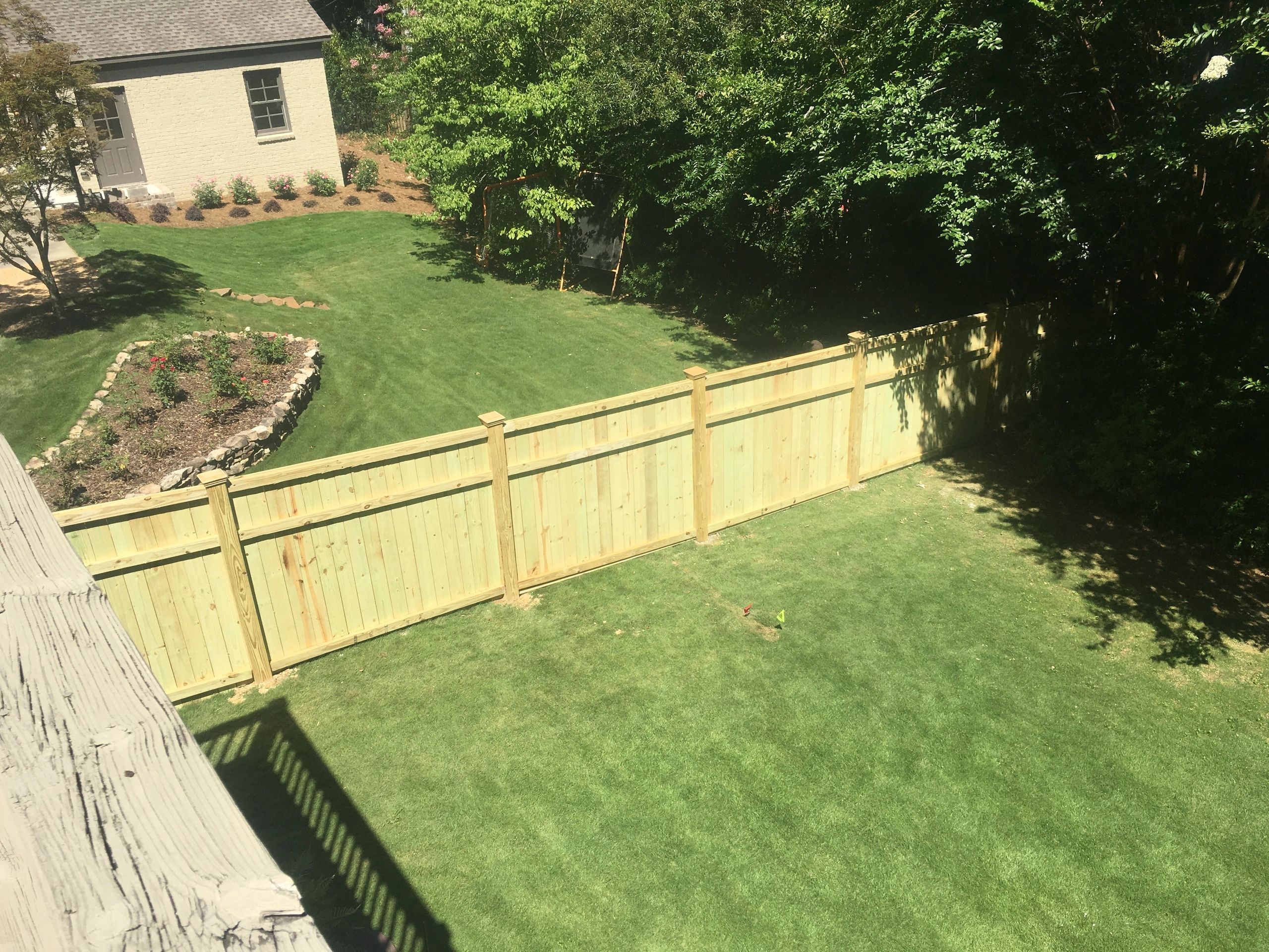 Sunny backyard with fresh fence and garden.