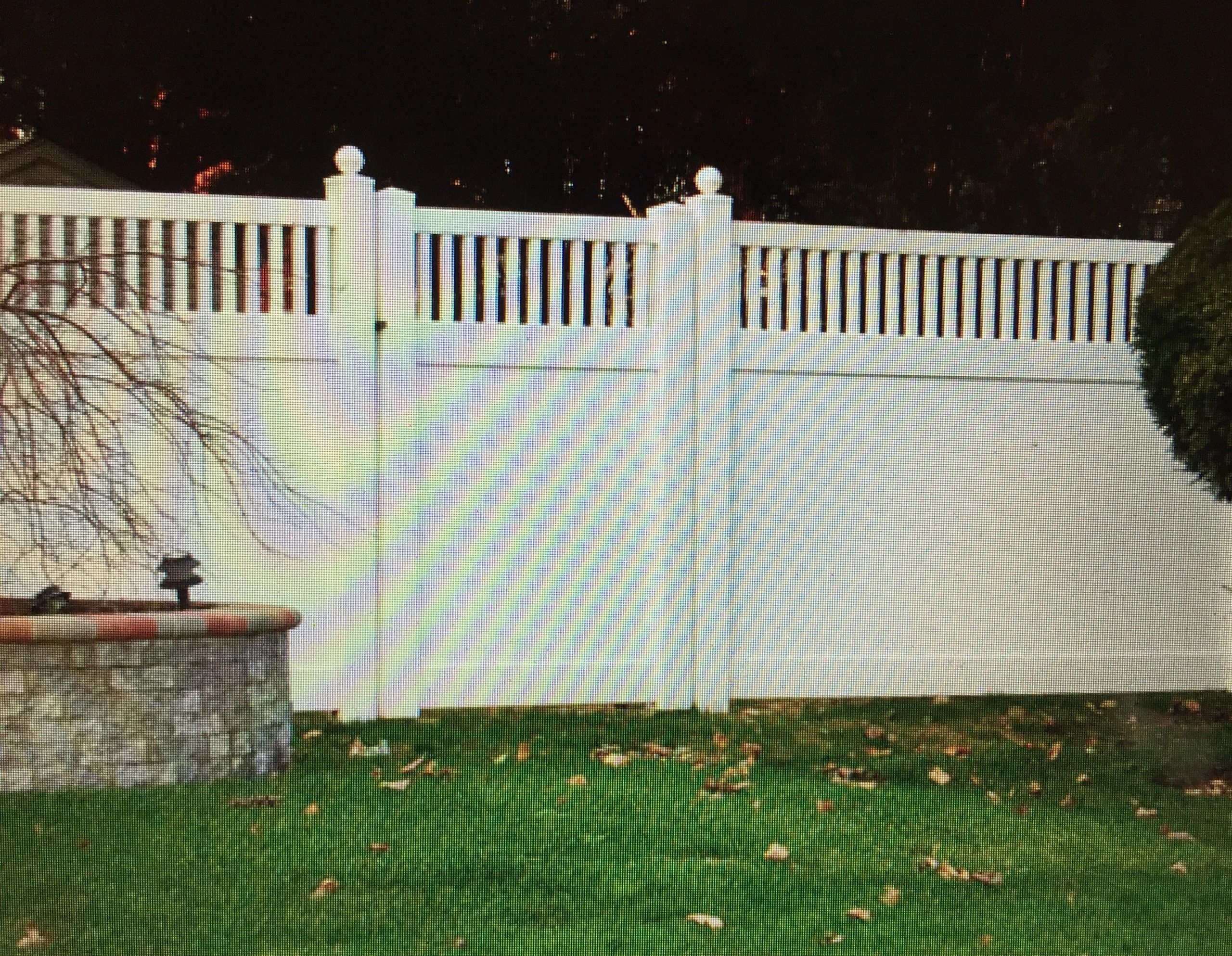 Elegant vinyl fence with decorative top.