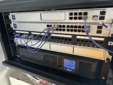 Network switch with multiple Ethernet cables connected inside a server rack.