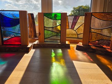Collection of stained glass pieces displayed as interior design accessories. Stained glass in hand c
