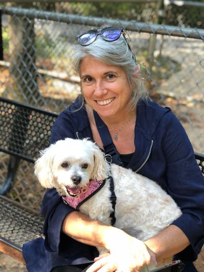 Dog transport specialist and pup relax on a bench.