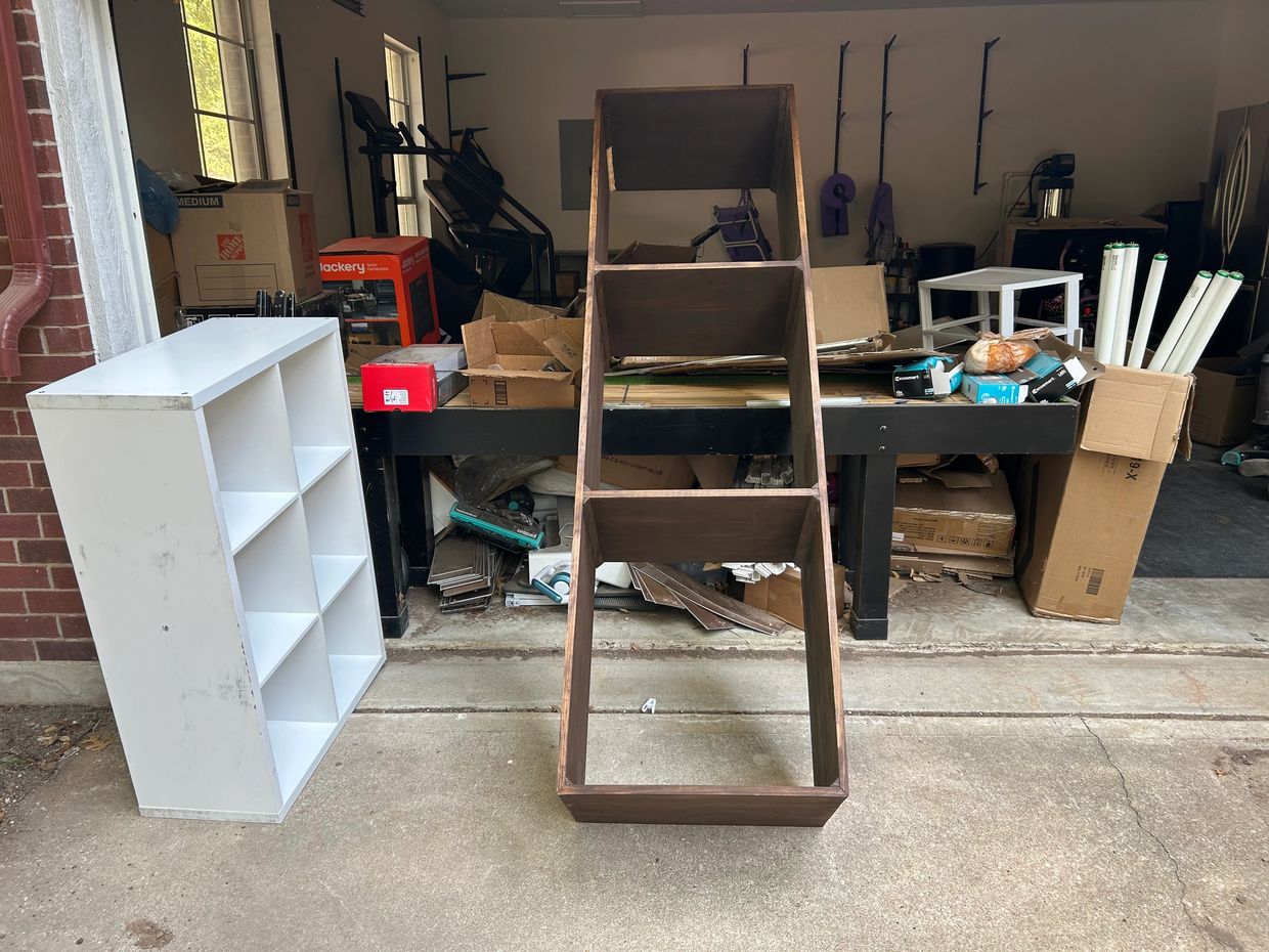 Wooden and white shelves with boxes and tools in a garage workspace.