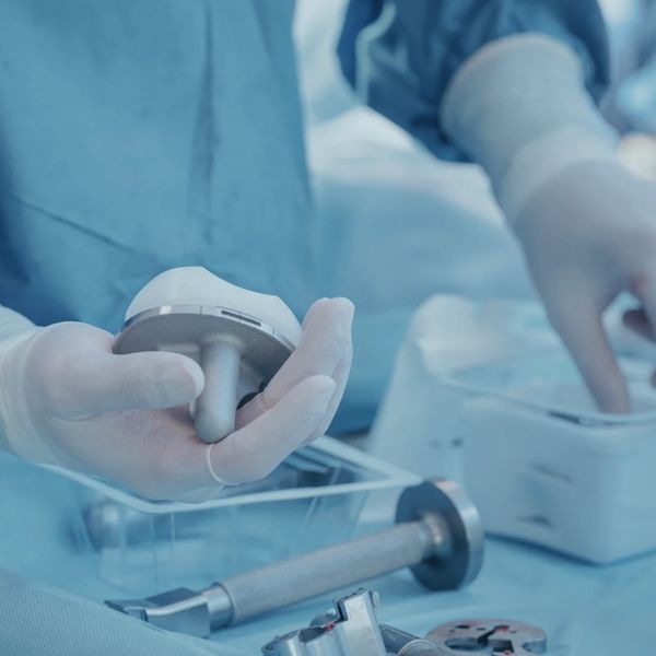 Surgeon holding a medical implant in an operating room.