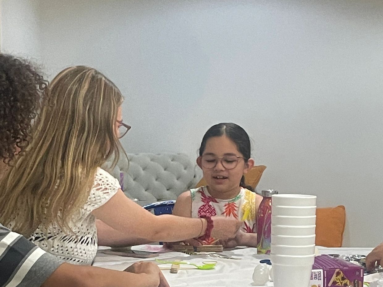 Two girls engaging in a craft activity at a table.