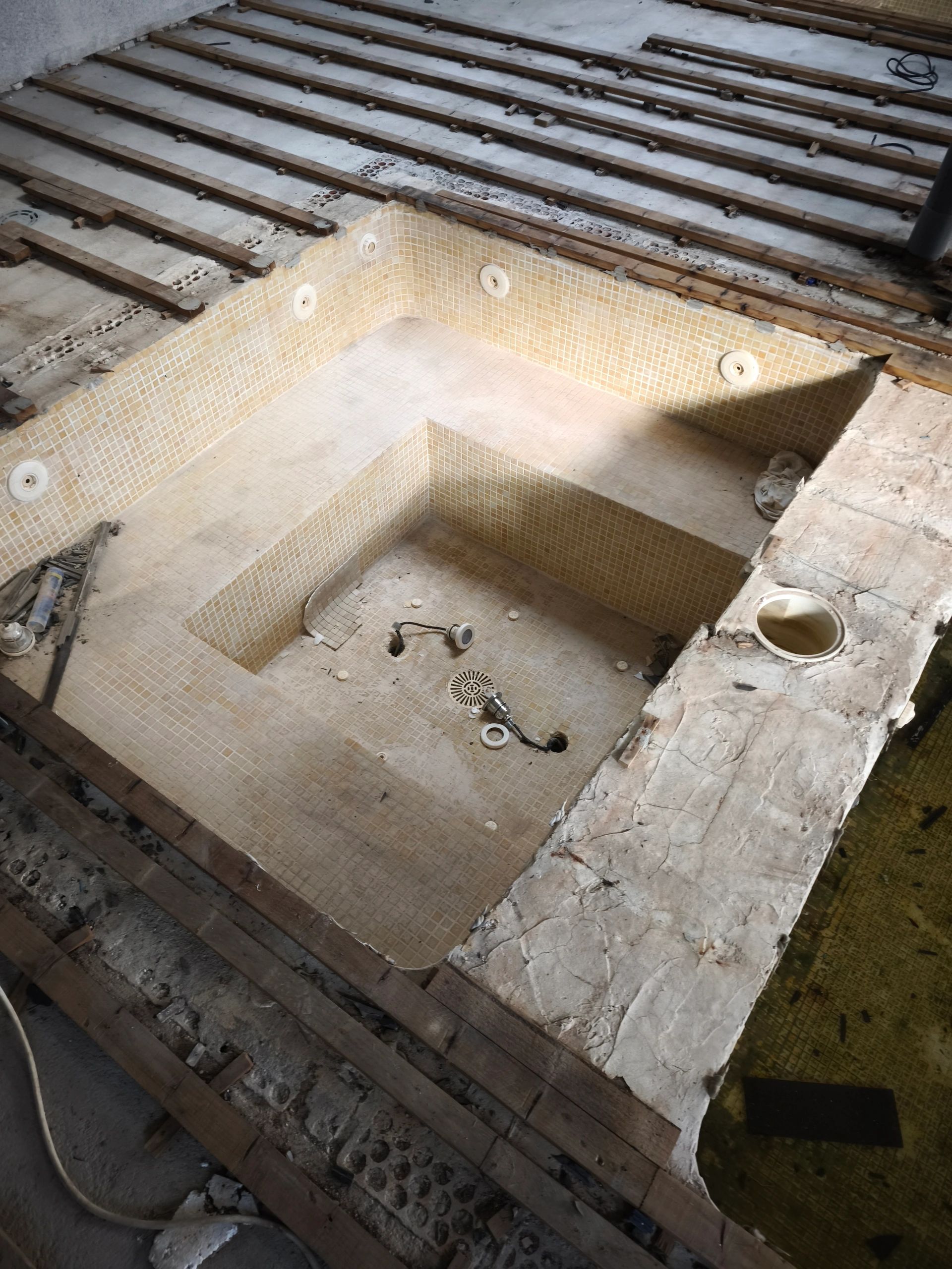 Piscina vacía en construcción con estructura de madera.