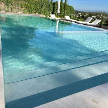 Piscina al aire libre con agua cristalina y tumbonas.