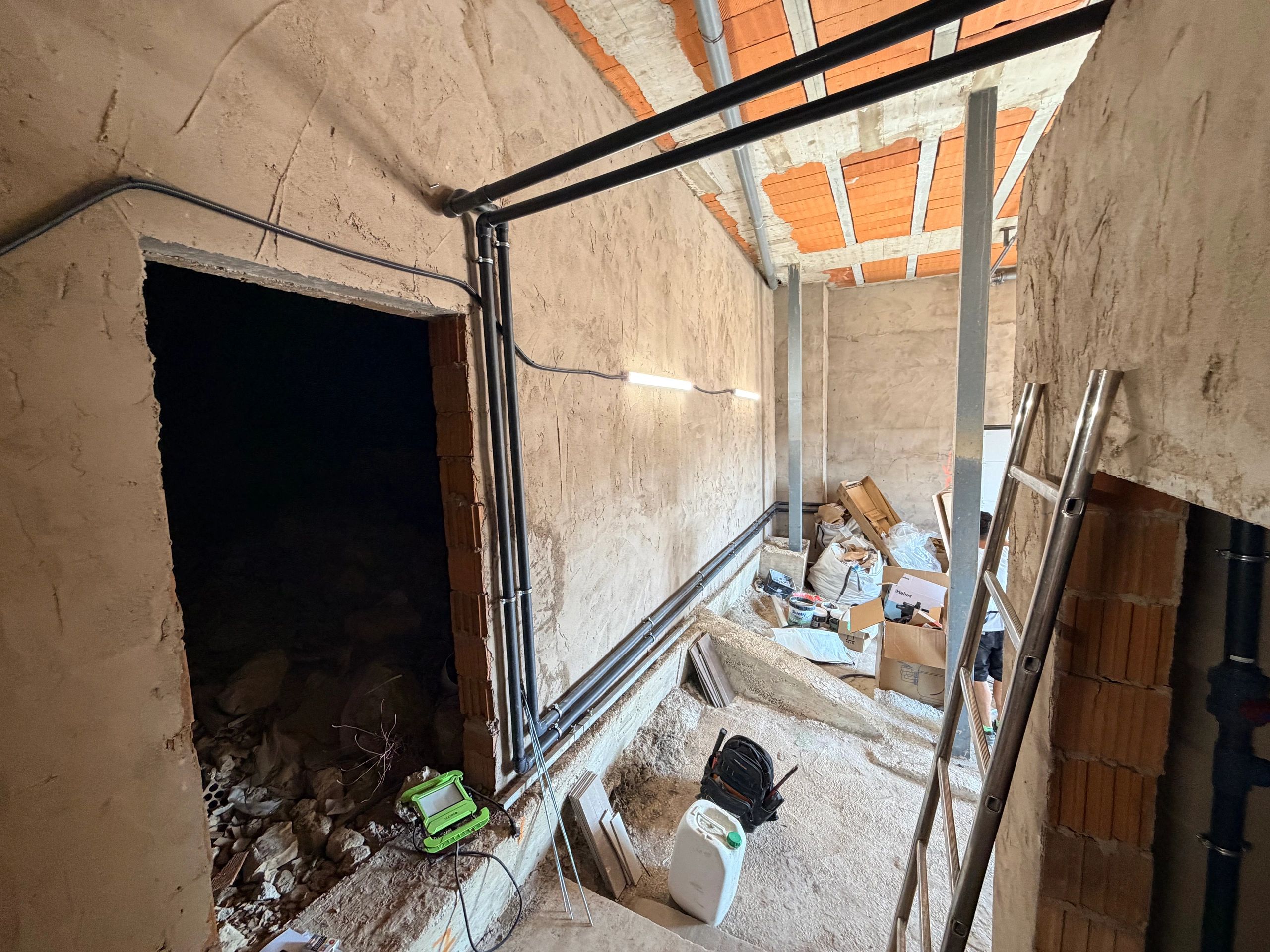 Obra en construcción con tuberías y materiales.