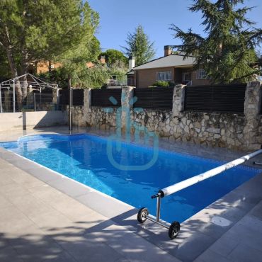 Piscina limpia en un patio trasero soleado.