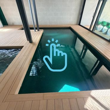 Piscina interior con marco de madera y columnas negras.