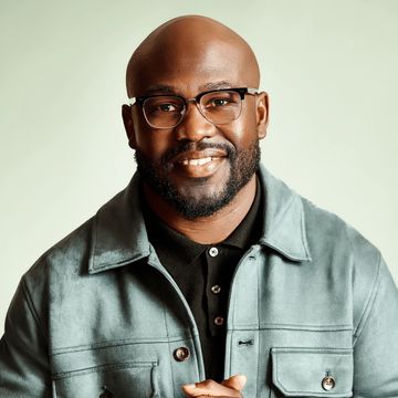 Smiling man wearing glasses and a jacket.