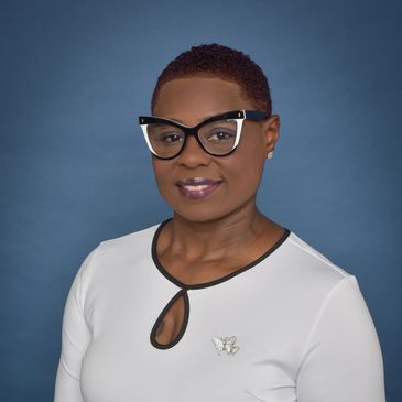 Professional woman with stylish glasses and a white top against a blue background.
