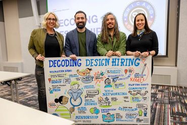 Four people holding a colorful poster titled 'Decoding Design Hiring.'
