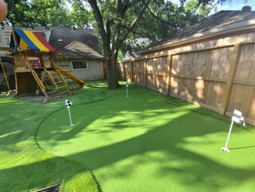 backyard Putting green next to playground with fake grass