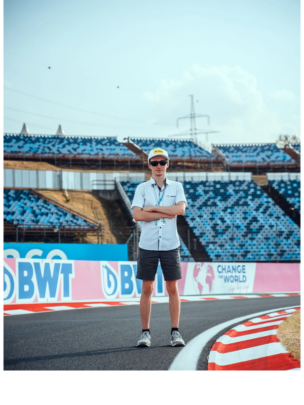 A photo of Michael at the Hungaroring in front of track signage.