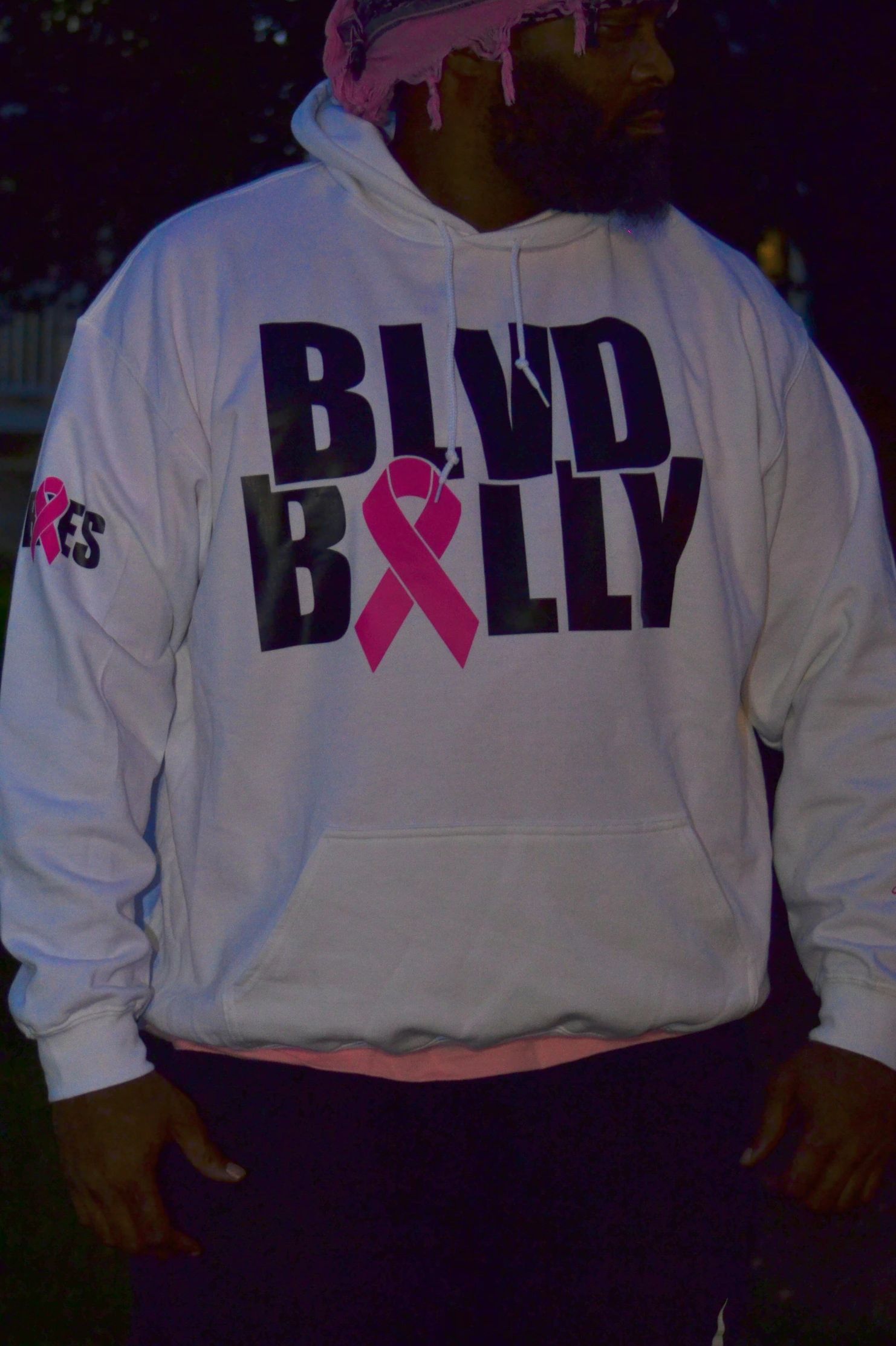 Person wearing white hoodie with BLVD BILLY and pink ribbon design.