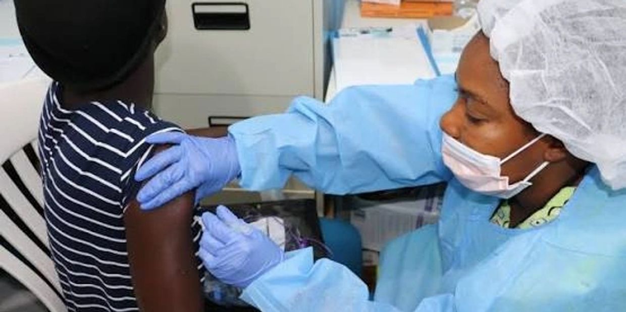 Healthcare worker administering vaccine to a patient.