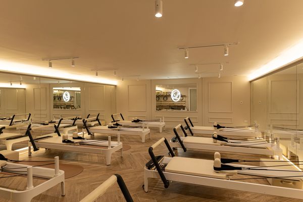 Sala de pilates con muchas máquinas.