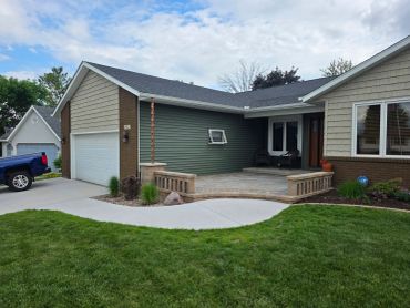 Suburban house with green siding and a front porch.