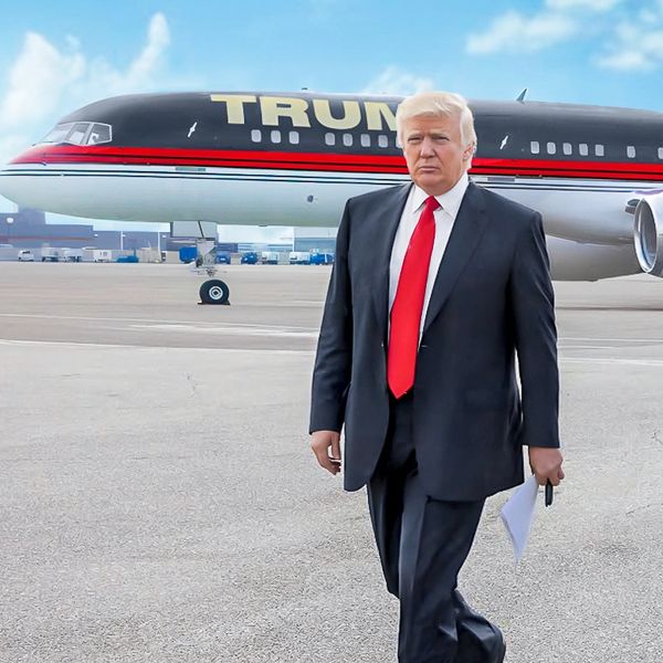 Donald J. Trump walking with plane labeled "Trump" in the background. 
Photo credit: The Trump Organ
