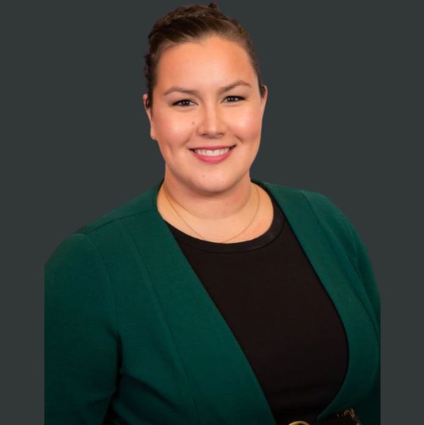 Professional photo of a woman with dark hair and green jacket. 